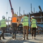 Diverse Team Of Specialists Inspect Commercial Industrial Building Construction Site